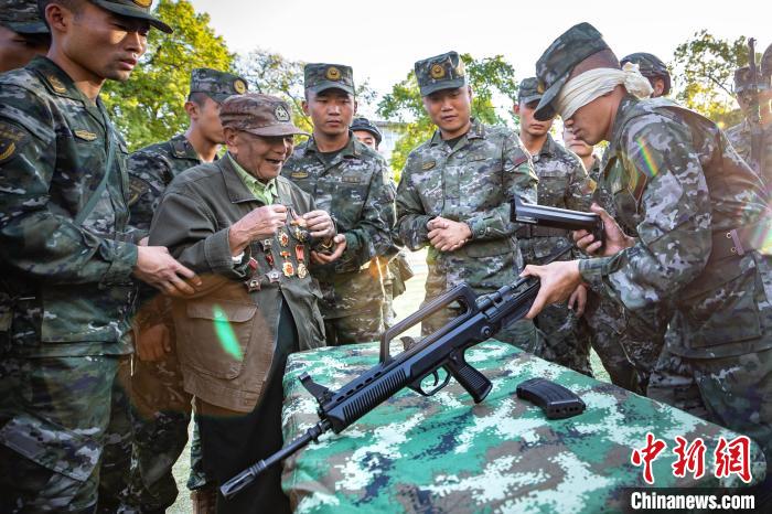 训练场，战斗英雄李渭清观看官兵无光条件下武器分解结合课目训练。?　施晨洲？　摄